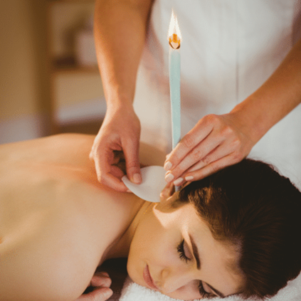 Professional ear candling session using ear wax candles for relaxation and earwax removal