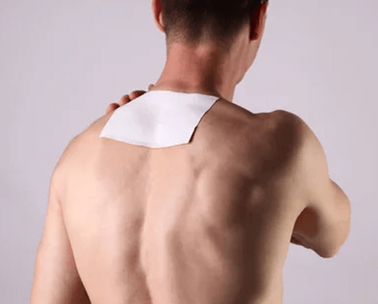 A man with a white pain relief patch on his back in Australia.